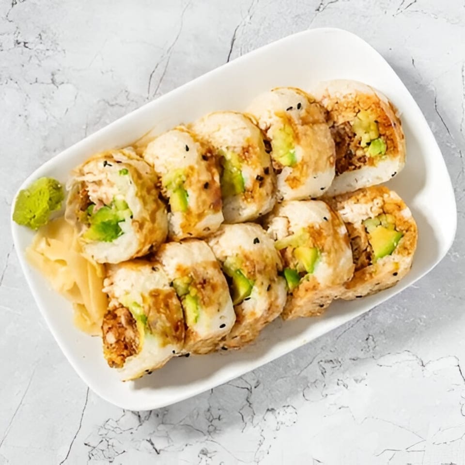 Japon's sushi rolls with avocado and brown filling, served with wasabi and ginger.